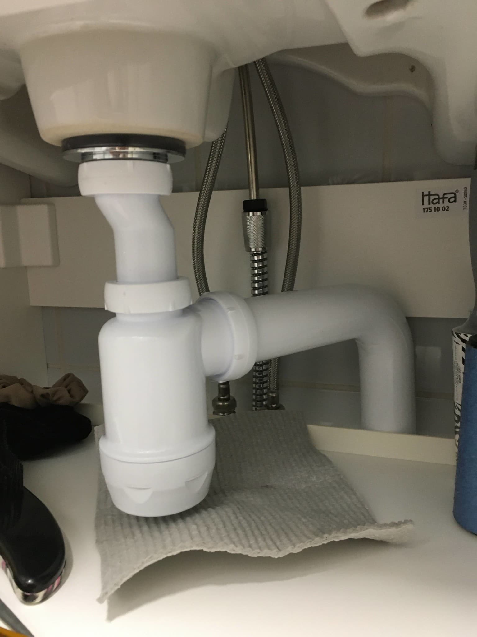 Rör under handfat med dropp och trasa under